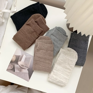 Cozy knit mid-calf socks in earthy tones including black, coffee, and grey