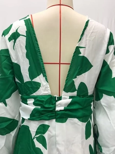 Detail of deep V-back design and leaf print on a green and white maxi dress