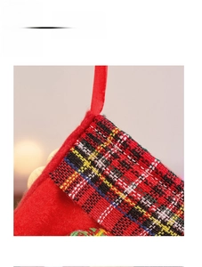 Detailed macro view of festive red felt Christmas stocking with classic plaid fabric trim