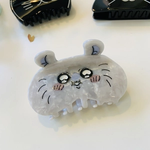Detail of cute cat shaped hair claw clip with marble texture and cartoon feline face