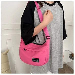 Close-up of pink nylon underarm bag showing the durable fabric texture and square brand logo