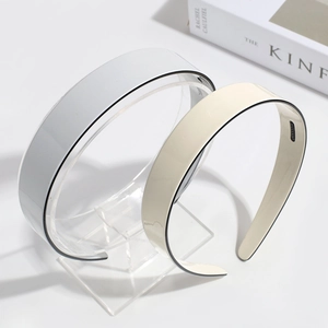 Detail view of wide-brimmed non-slip hairbands in grey and beige cream colors