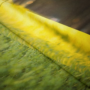 Close-up of soft flannel tapestry showing vibrant green forest and bokeh sunlight details