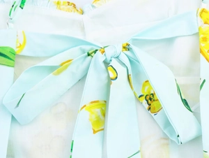 Dettaglio dell'abito in popeline azzurro con stampa di limoni e fiocco in vita