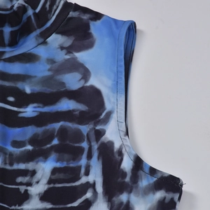 Detail of high neck and sleeveless cut on blue and black tie-dye knit dress fabric