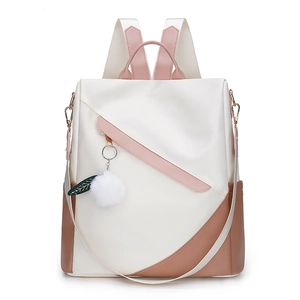 Detail of waterproof nylon backpack featuring color-block design and white pompom charm