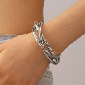 Close-up of triple-layered silver coil wrap bracelet worn on a female wrist