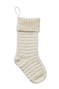 Detailed view of cream-white knitted Christmas stocking with intricate geometric patterns