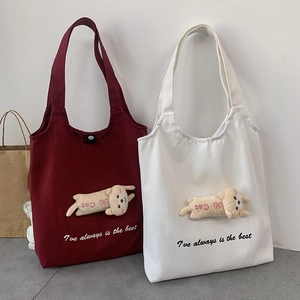 Detail of burgundy and white canvas tote bags featuring 3D cute cat dolls and embroidery