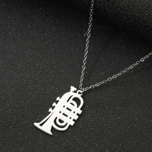 Detailed close-up of a polished silver trumpet silhouette pendant on a delicate metal chain