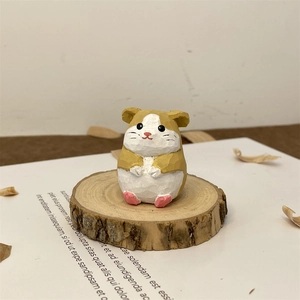 Macro shot of a hand-carved wooden hamster figurine on a rustic timber base