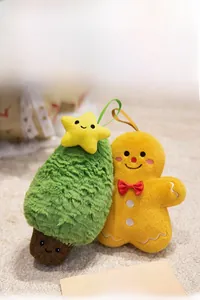 Detail view of plush Christmas tree and gingerbread man ornaments on soft beige rug