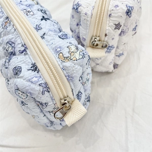 Detailed close-up of quilted cotton fabric with cute cat and moon cartoon patterns