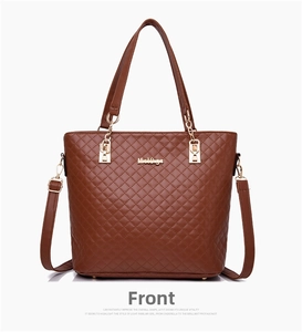 Detailed view of brown quilted tote bag with gold metal logo and chain strap accents