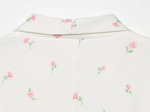 Detailaufnahme von Reverskragen und rosa Blumendruck auf weißem Freizeit-Blazer