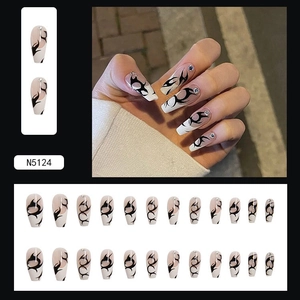 Detail of long coffin press-on nails featuring black flame tribal art and silver rhinestones