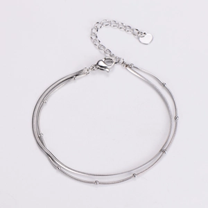 Close-up of double-layer silver beaded snake chain bracelet with heart pendant and lobster clasp