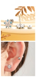 Detail of snowflake stud earrings with blue and white zircons and screw back closure