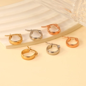 Three pairs of oversized stainless steel hoop earrings in gold, silver, and rose gold finishes