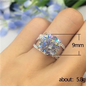 Classic four-prong cubic zirconia cross ring with 9mm main stone on woman's finger