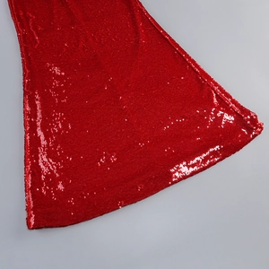 Detailed macro view of the shimmering red sequins and fishtail hem on this evening gown