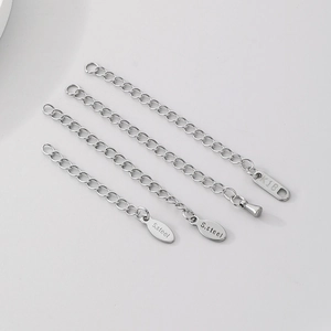 Three silver stainless steel extender chains with S.Steel and K18 tags on white background