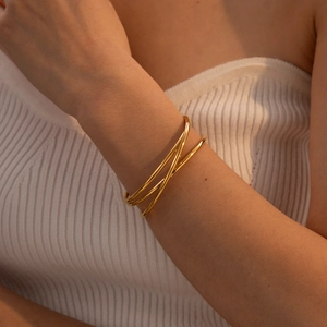 Detalle del brazalete multicapa de acero inoxidable chapado en oro de 18k en la muñeca