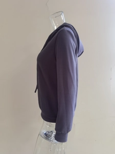 Detalle de sudadera con capucha de punto acanalado morado oscuro con mangas largas suaves