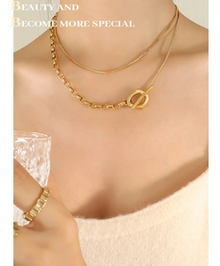 Detailed view of layered 18k gold-plated snake and cable chain necklace with toggle clasp