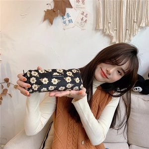 Detailed view of daisy pattern corduroy pencil case and vintage textile cosmetic bag