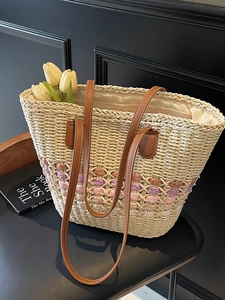 Chic beige straw tote bag with colorful woven patterns and elegant yellow tulips