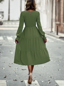 Détail d'une robe longue vert armée à manches longues et jupe à plusieurs niveaux et dos nu