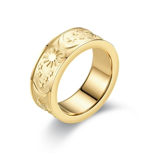 Detalle de anillo de acero de titanio dorado con grabado celestial de sol luna estrella