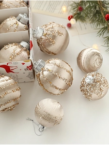 Detail of champagne Christmas ornaments with gold beads and sequins in festive box