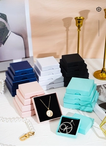 Detail of square jewelry boxes in multiple colors with flocked velvet inserts for display