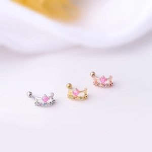 Detailed close-up of three 20G stainless steel cartilage earrings with cat eye and zircon