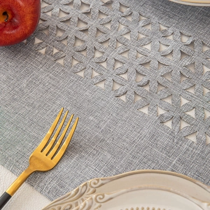 Gray woven table runner with hollow floral pattern in a minimalist country dining set