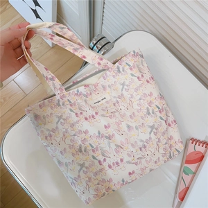 Close-up of floral cotton tote bag with 'Simple Wish' label and gray zipper closure