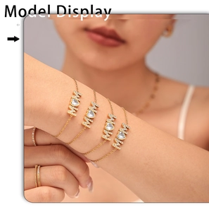 Detail of layered gold MOM bracelets with heart zircon charms worn on model's wrist