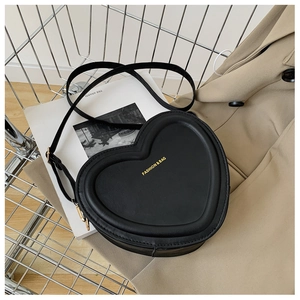 Dettaglio di una borsa a tracolla nera in pelle a forma di cuore in un carrello d'argento