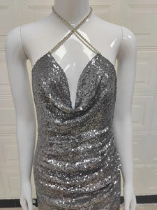 Détail de paillettes argentées scintillantes et de bretelles croisées en strass sur la robe
