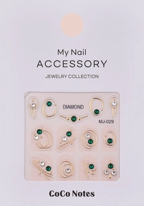 Detail of luxury nail art stickers with gold geometric frames and emerald rhinestones