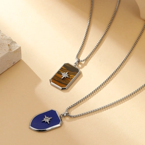 Detailed close-up of shield pendants with star inlay on gold finish box chains