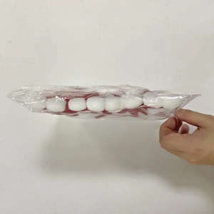 Close-up of mini red and white plush pom-poms for Christmas bottle decoration sets