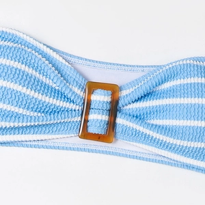 Detail of blue striped seersucker bikini fabric with amber tortoise shell buckle