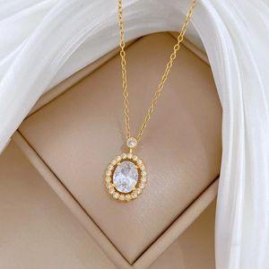 Golden titanium steel necklace with oval zircon pendant on jewelry box display