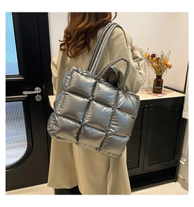 Vista posteriore della borsa tote trapuntata argento sul modello in un interno accogliente