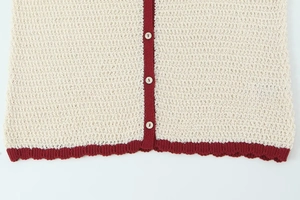 Macro detail of knit texture with wine red contrast edge and white smooth buttons