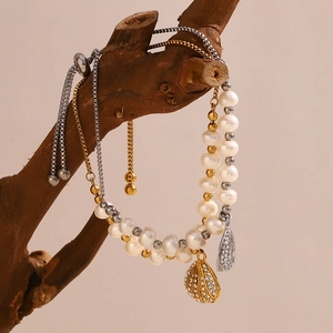Adjustable 18K gold plated pearl bracelet with shell charms on a natural wood branch