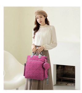 Pink quilted backpack for moms featuring gray straps and a matching round coin purse charm